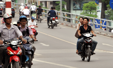 Thế nhưng bất chấp quy định của pháp luật, nhiều người vẫn đầu trần khi điều khiển xe máy chạy ngoài đường...