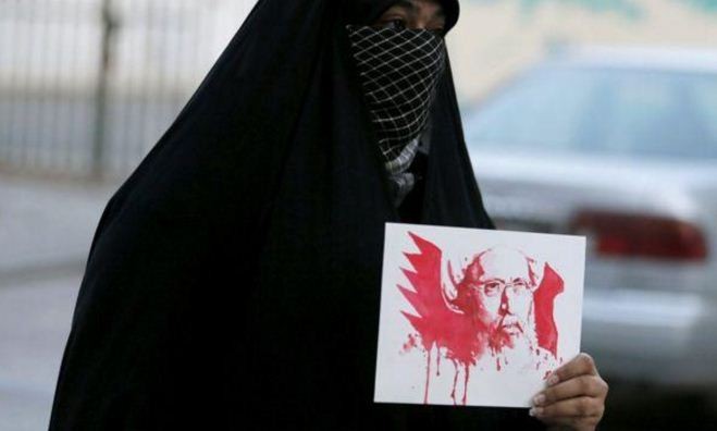 Một người phụ nữ Bahrain mang tấm hình Giáo sĩ Sheikh Nimr al-Nimr – người mà cái chết đã mở đầu cho cuộc khủng hoảng Iran - Ả rập. Ảnh: Reuters.
