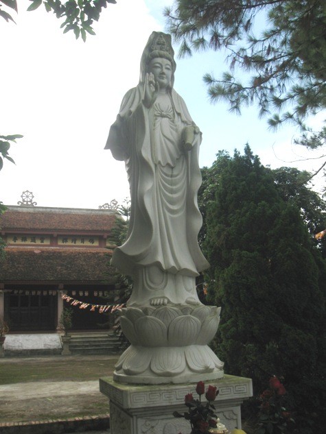 Tượng Phật Quan Thế Âm Bồ Tát được tạc bằng đá sừng sững trước lối lên chùa