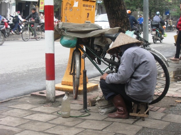 Hình ảnh ông lão vá xe ngồi rúm ró gây chú ý cho nhiều người khi đi lại qua đường Thanh Nhàn