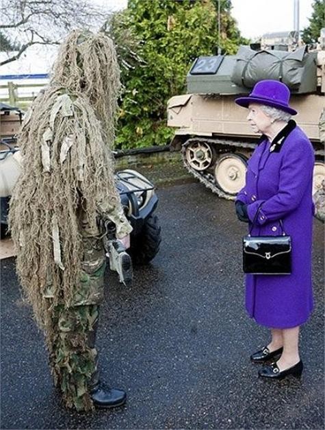 Nữ hoàng Anh Elizabeth II ngắm nhìn một lính bắn tỉa trong bộ quần áo ngụy trang của anh ta