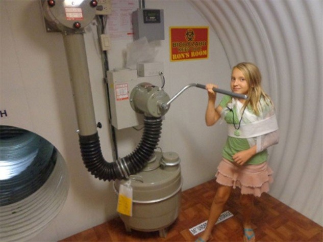 Một bé gái quay máy bơm nước trong chiếc hầm trú ẩn.