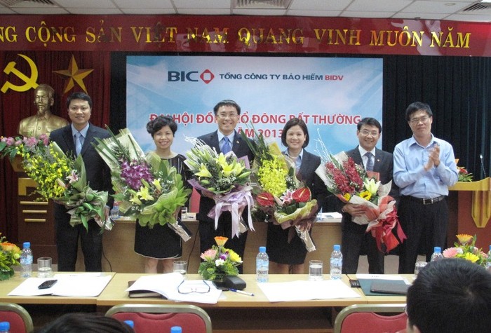 Ông Nguyễn Huy Tựa - Ủy viên HĐQT BIDV (áo xanh) đã thay mặt cổ đông lớn BIDV và toàn thể cổ đông tặng hoa và chúc mừng các thành viên Hội đồng Quản trị mới của BIC.