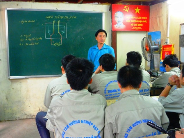 Ông Hà Văn Khang (ánh xanh da trời trên mục giảng) giáo viên lớp kỹ thuật sửa chữa ô tô (Trung tâm dạy nghề Thanh Xuân – Hà Nội).