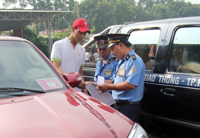 Lực lượng chức năng ở TP HCM xử phạt taxi Uber. Ảnh: Hữu Công