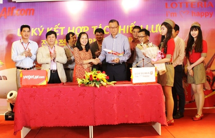 Bà Nguyễn Thị Thúy Bình, Phó Tổng Giám đốc Vietjet tặng quà lưu niệm cho ông Kang Hyung Hee - TGĐ Lotteria Việt Nam tại buổi lễ ký kết