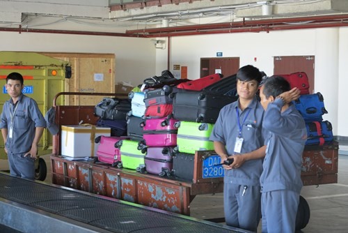 Theo quy định nhân viên bốc xếp hàng hóa không được mặc quần áo có túi nhưng thực tế vẫn còn nhiều nhân viên phục vụ hành lý mặc trang phục có túi (ảnh nguồn Thanh niên)