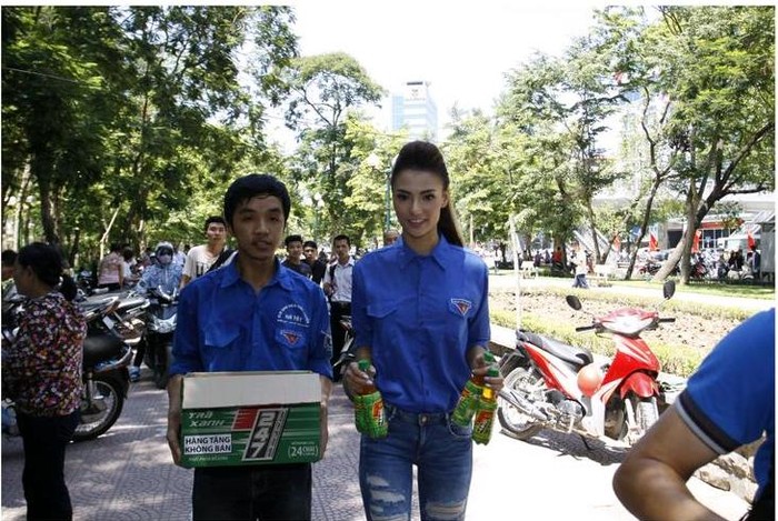 Người mẫu Hồng Quế tươi tắn trong màu áo xanh tình nguyện hăng hái tham gia chương trình phát nước miễn phí này.
