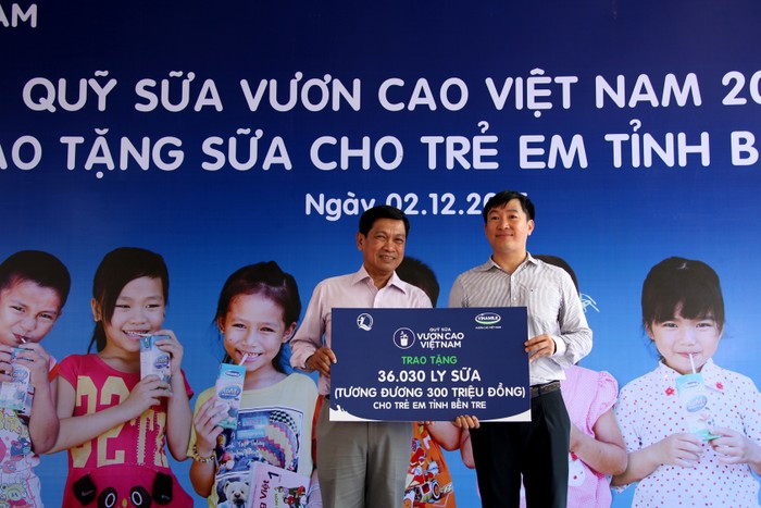 Ông Đỗ Thanh Tuấn, Trưởng bộ phận Đối ngoại Vinamilk trao tặng bảng tượng trưng 36.030 ly sữa tương đương 300 triệu đồng cho đại diện Quỹ Bảo trợ trẻ em tỉnh Bến Tre.