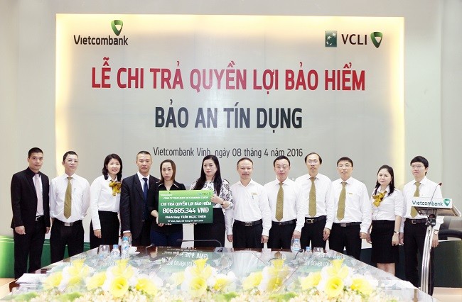 Bà Lê Thị Huệ Anh - Giám đốc Vietcombank Vinh (thứ 8 từ phải sang) trao quyền lợi bảo hiểm nhân thọ Bảo an Tín dụng cho người thụ hưởng Trần Thị Mai Phương