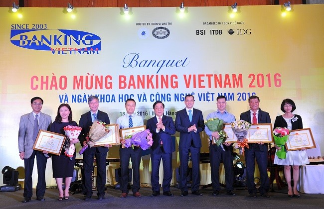 Đại diện tập thể Vietcombank, ông Nguyễn Danh Lương - Ủy viên HĐQT, Phó Tổng giám đốc (thứ 3 từ trái sang) đón nhận sự vinh danh, đồng thời vinh dự nhận Bằng khen của Thống đốc NHNN dành cho cá nhân đạt thành tích xuất sắc trong hoạt động khoa học và công nghệ ngân hàng giai đoạn 2011 - 2015.