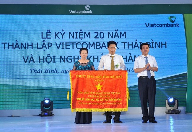 Đại diện UBND tính, ông Nguyễn Hoàng Giang - Tỉnh ủy viên, Phó chủ tịch UBND tỉnh ( ngoài cùng bên phải) tặng bức trướng cho Vietcombank Thái Bình.