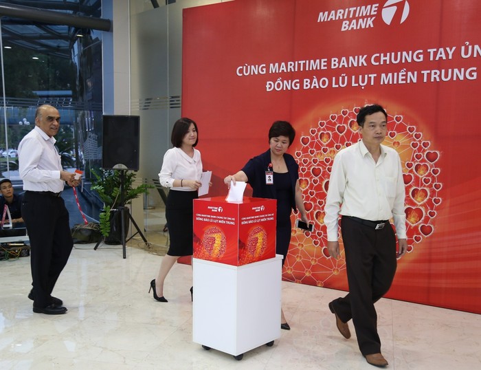 Cán bộ nhân viên Maritime Bank bỏ tiền vào thùng ủng hộ đồng bào miền Trung.