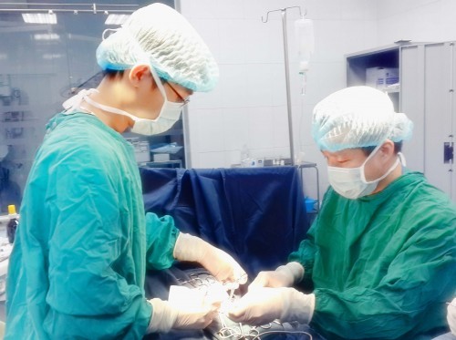 PGS Trần Ngọc Sơn (người đứng bên phải) trong quá trình phẫu thuật cho bé Thanh Bình ( Ảnh: Bác sĩ cung cấp)