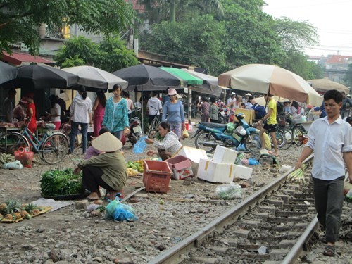 Hình ảnh họp chợ ngay bên cạnh đường ray trong khu vực an toàn đường sắt diễn ra tại Cổ Nhuế khiến nhiều người không khỏi lo lắng về nguy cơ tai nạn đường sắt - ảnh nguồn An ninh thủ đô.
