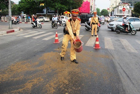 Hình ảnh chiến sĩ cảnh sát giao thông dọn dầu loang trên phố tránh việc người tham gia giao thông bị trượt ngã được dư luận đánh giá cao.- ảnh nguồn VTCNews.