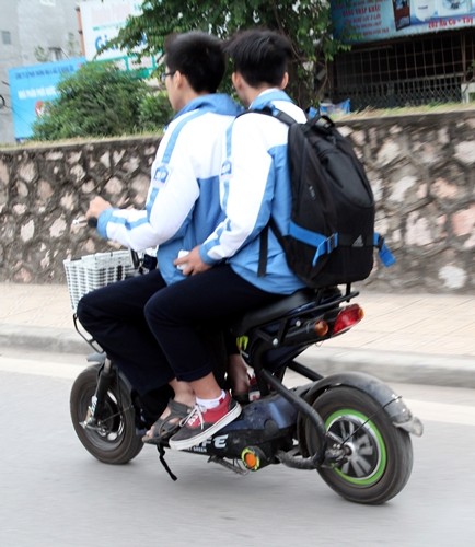 Hiện tượng học sinh tham gia giao thông bằng xe đạp điện, xe máy điện không đội mũ bảo hiểm xuất hiện nhiều trên các tuyến phố - ảnh nguồn: Báo Giao thông vận tải.