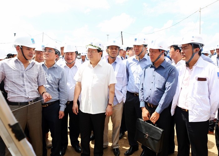 Phó Thủ tướng Trịnh Đình Dũng cùng đoàn công tác nghe báo cáo về Dự án Nhà máy Điện lực Dầu khí Long Phú 1 tại công trường - ảnh nguồn PVN.