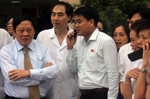 Giám đốc bệnh viện Nguyễn Viết Tiến, Phó giám đốc công an Hà Nội, Đại tá Nguyễn Đức Chung (người đứng giữa ảnh) cũng ra cổng bệnh viện chờ xe đưa cháu bé về. (ảnh VNE)