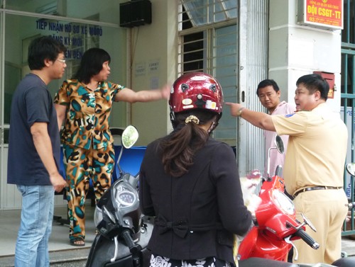 Cuộc "khẩu chiến" diễn ra trước sự chứng kiến của những người đến Đội CSGT quận Hải Châu làm thủ tục đăng ký biển số xe máy (Ảnh: Hải Châu - infonet)