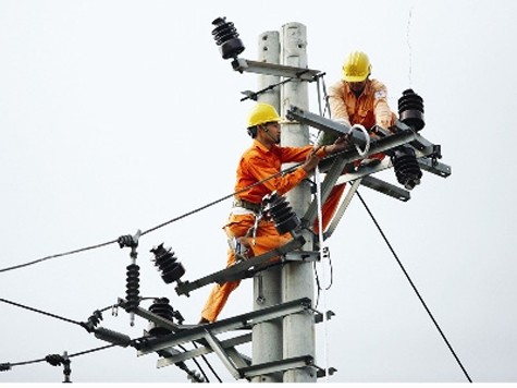 Công nhân điện lực đang thi công mạng lưới điện tại cầu Vĩnh Tuy (Hà Nội)