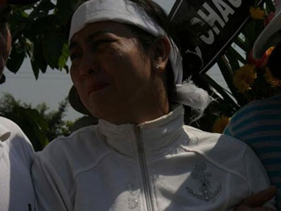Bà Trần Thúy Liễu, vợ nhà báo Hoàng Hùng trong đám tang của chồng