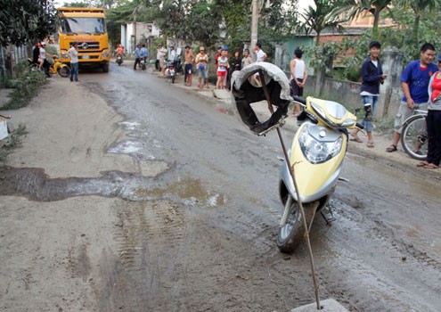 Chiếc xe máy của người dân bị tai nạn được dựng ngay giữa đường để chặn đoàn xe ben. Ảnh: Nguyễn Đông
