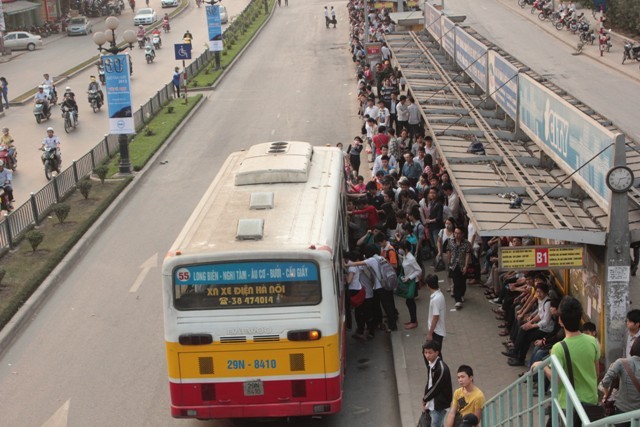 Khi xe buýt tới bến, mọi người chen nhau để được lên xe.