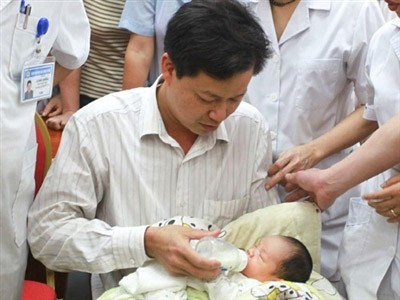 Anh Phạm Xuân Chiều cho con uống sữa sau khi cơ quan công an trao cháu bé cho gia đình (Ảnh: Tiền Phong)