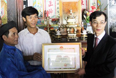 Ông Lên, anh Thành (bên trái sang) đang nhận bằng khen của Bộ Ngoại giao trao tặng.
