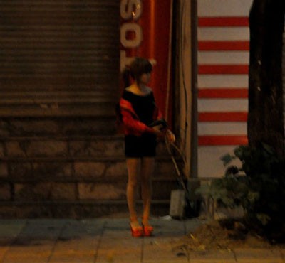 Một gái mại dâm đứng chờ khách trên đường