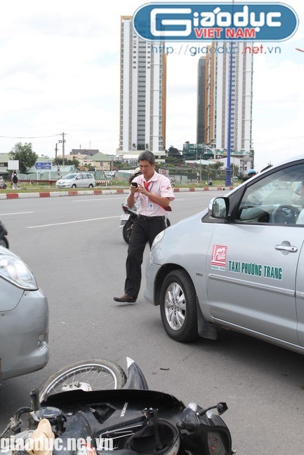 Anh Nguyễn Văn Tâm, 20 tuổi (ngụ tại Tiền Giang) - người điều khiển xe máy biển số 48H1 – 4872 do không kịp xử lý đã tông thẳng vào bên phải xe taxi, ngã xuống đường và bất tỉnh. Trong ảnh: Tài xế taxi mải mê với chiếc điện thoại còn người bị nạn vẫn đang nằm sõng soài dưới đường