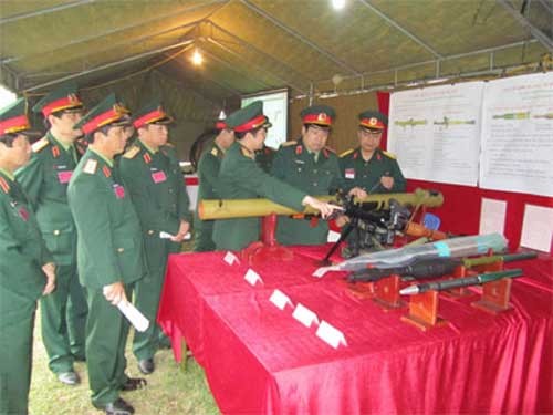 Bộ trưởng Quốc phòng, Đại tướng Phùng Quang Thanh, tham quan các sản phẩm của Tổng Cục Công nghiệp quốc phòng. Ống phóng màu vàng gần Bộ trưởng là RPG-29. Quả đạn thứ 3 từ ngoài vào là đạn xuyên giáp PG-29V dùng cho RPG-29. Ảnh: Quân đội nhân dân.