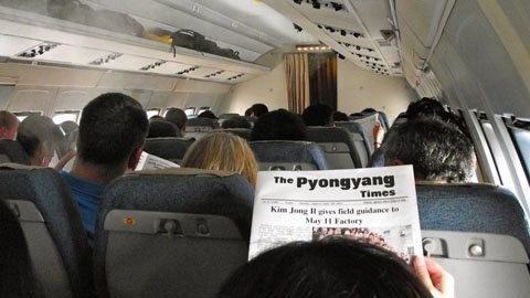 Trên trang nhất của báo được phát trên chuyến bay là hình của lãnh đạo Kim Jong Il