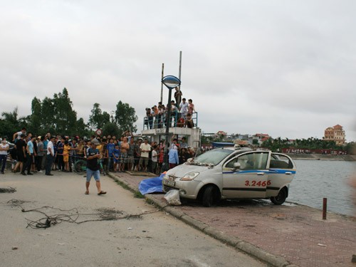 Chiếc taxi cùng xác tài xế được lực lượng chức năng đưa lên bờ hồ