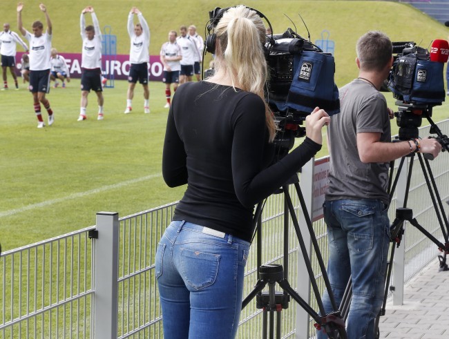 Một nữ phóng viên xinh đẹp theo dõi các hoạt động của các cầu thủ trên sân tập.