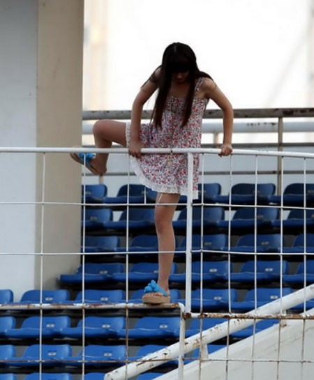 Một cô gái diện váy táo bạo trèo qua tường rào để tận mắt xem Drogba luyện tập.