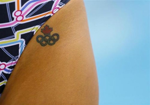 Một vận động viên bơi người Canada để lộ hình xăm biểu tượng Olympic, còn phía trên là biểu tượng quốc kỳ Canada.