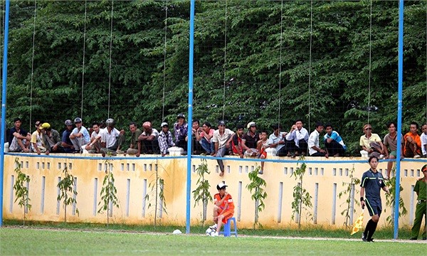 Rất nhiều người chọn tường bao quanh sân là chỗ ngồi để theo dõi trận đấu.