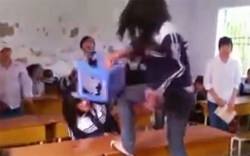Hình ảnh một nữ sinh cầm ghế đánh lên đầu bạn trong một clip được tung lên mạng xã hội