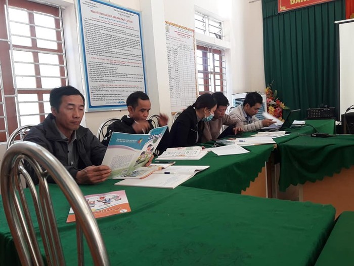 Giáo viên trường Mường Típ 1 huyện Kỳ Sơn đang đọc sách giáo khoa lớp 1 để bình chọn (Ảnh CTV)