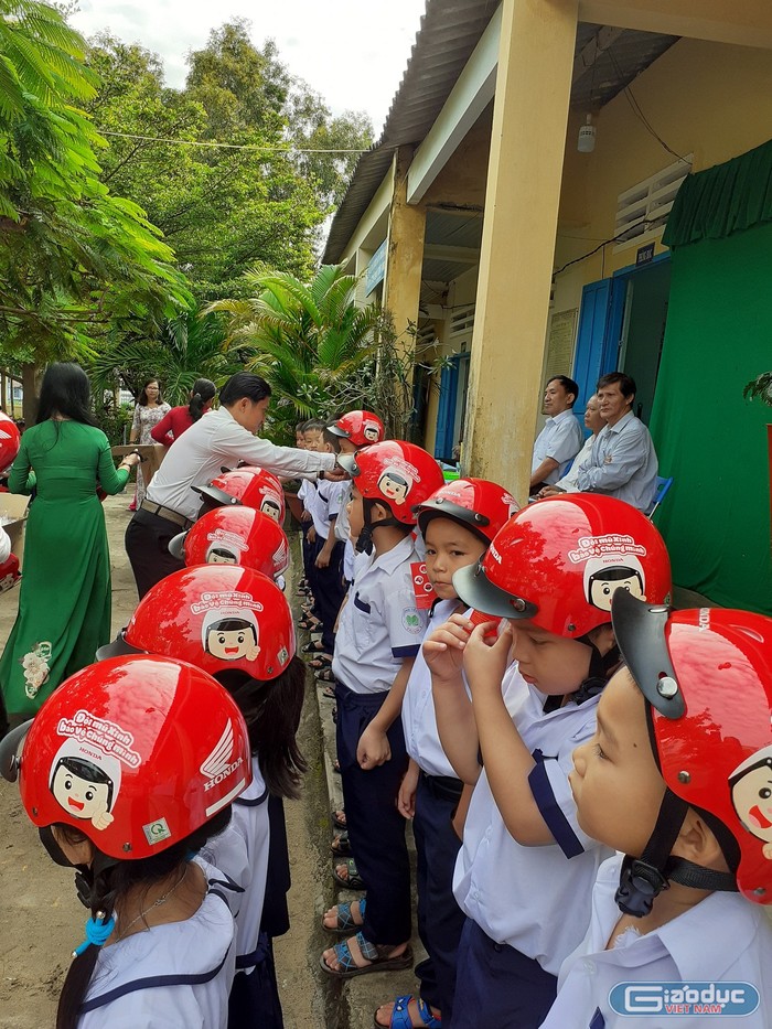 Học sinh lớp 1 nhận nón bảo hiểm trong lễ khai giảng (Ảnh Phan Tuyết)