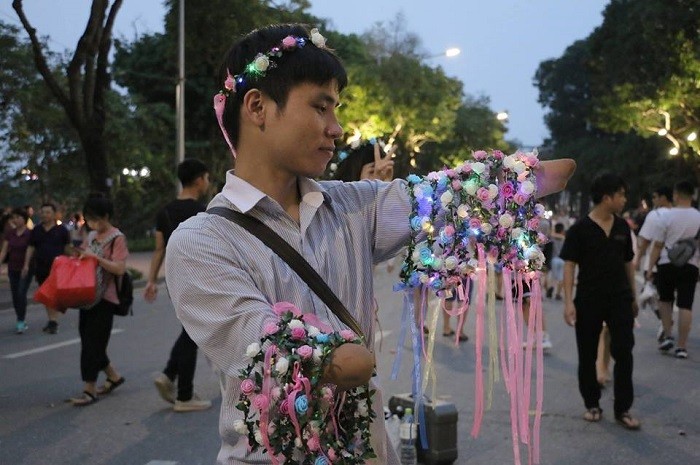 Phúc bán vòng hoa trên phố đi bộ để đỡ đần mẹ (Ảnh:NVCC)