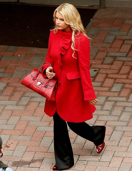 Jessica Simpson thật điệu đà và duyên dáng với chiếc áo khoác đỏ nhún bèo ở cổ và một chiếc quần ống vảy, giày và túi xách xuyệt tông.