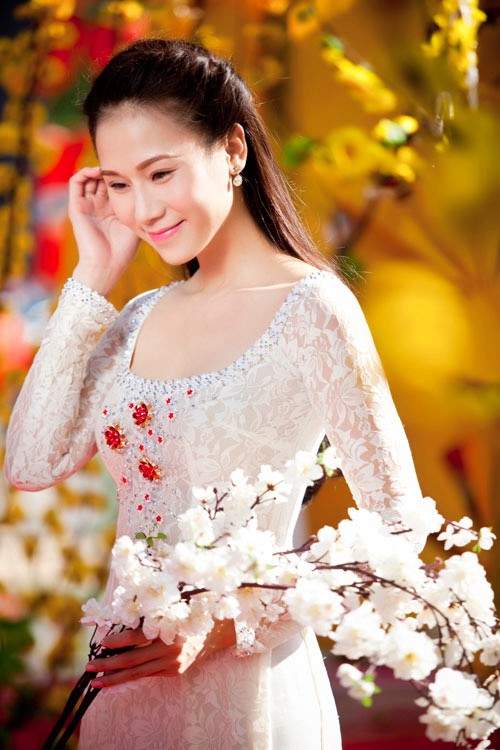 Á hậu Hà Nội 2005 - siêu mẫu Thái Hà mặc áo dài ren cách điệu e ấp bên hoa đào.