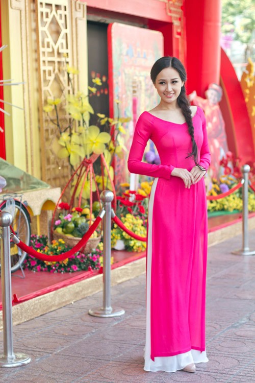 Hoa hậu Mai Phương Thúy chọn áo dài cổ rộng để lộ bờ vai trần khá gợi cảm. Mái tóc tết duyên dáng tôn lên vẻ rạng rỡ của hoa hậu.