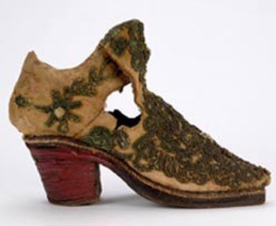 Một đôi giày cho trẻ em thế kỷ 17 (có thể là tại Pháp), đôi giày này có gót màu và lòng giày màu đỏ biểu tượng cho sự giàu có, quyền lực.