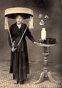 Một người phụ nữ Miền Bắc Việt Nam mặc áo tứ thân và đội nón quai thao; hình chụp đầu thế kỷ 19 (ảnh wikipedia)
