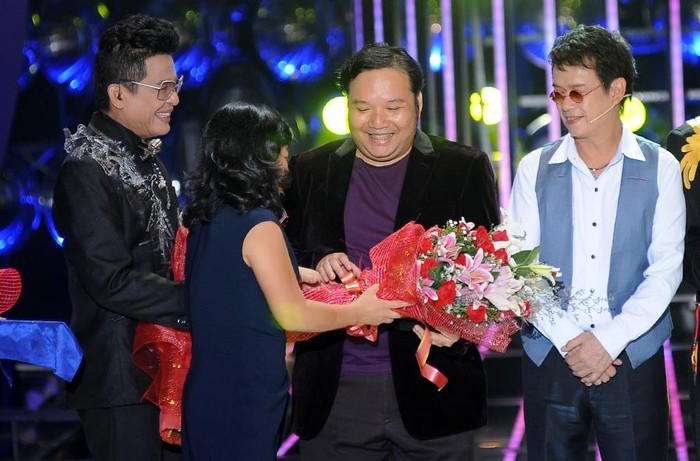 Nhạc sỹ, đạo diễn chương trình Nguyễn Hà (giữa) được tặng hoa trên sân khấu Gương mặt thân quen.