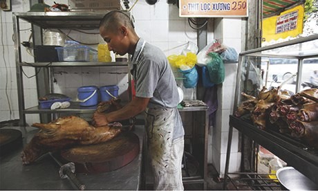 Ảnh trên tờ Theguardian: Một nhà hàng thịt chó tại Hà Nội. Ảnh: Luke Duggleby